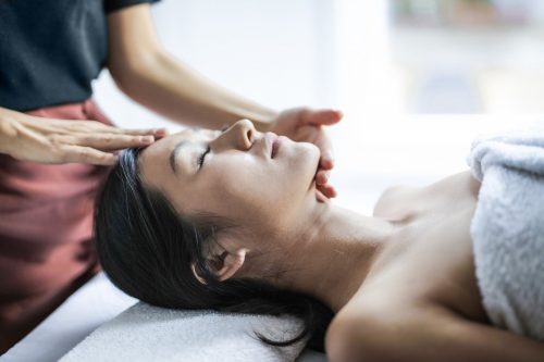 selective focus photo of woman getting a head massage